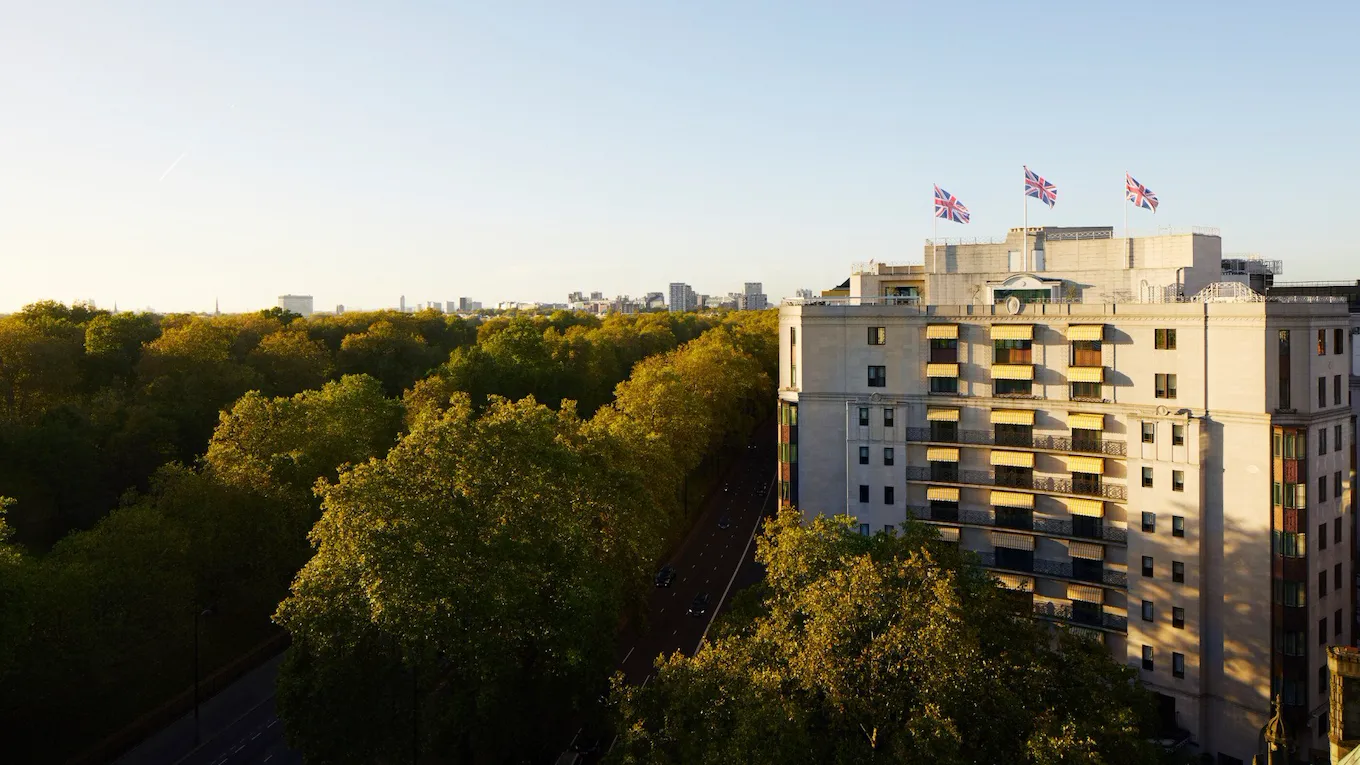 The Dorchester building exterior at sunset next to Hyde Park, London