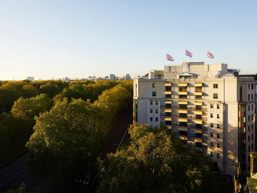 The Dorchester building exterior at sunset next to Hyde Park, London
