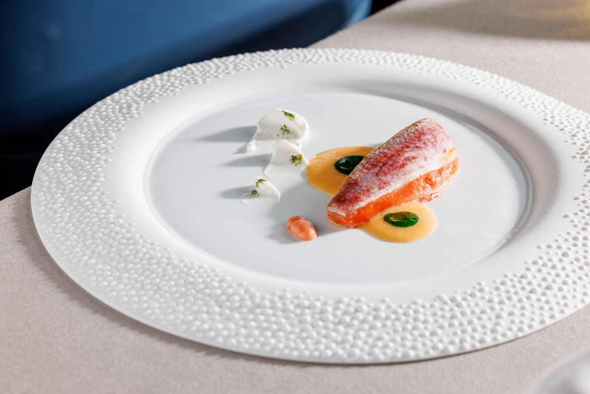 Fillet of red mullet with different sauces on a plate