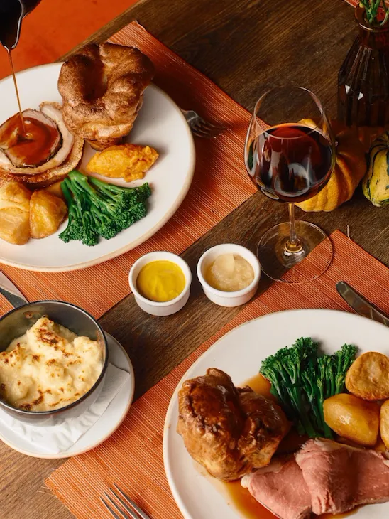 Sunday roast in The Barn at Coworth Park with seasonal vegeatbles, roast potatoes, yorkshire puddings and gravy. Accompanied by red wine.