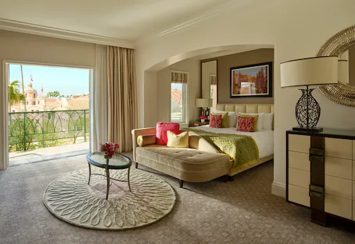 Deluxe guestroom with balcony, view of king bed and blue skies