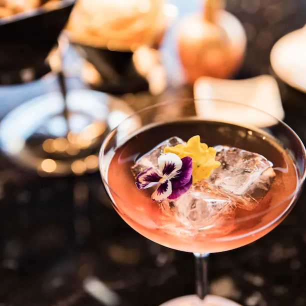 Aperitivo with one drink and nibbles in the background at Il Giardino Bar, Hotel Eden, Roma