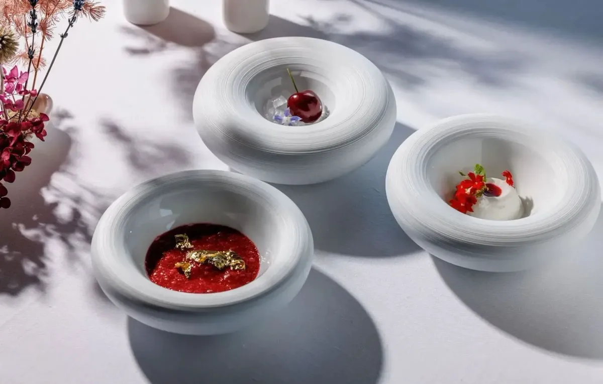 Three round dishes with the various elements of the dessert Donkey milk, cherry and roses from La Terrazza menu