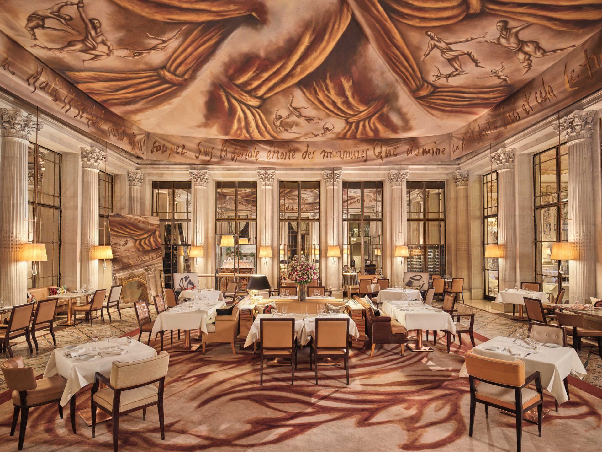 Large view on the restaurant Le Dali with all the dining furnitures, the mirror, the carpet and the painting on the ceiling, at Le Meurice, Paris
