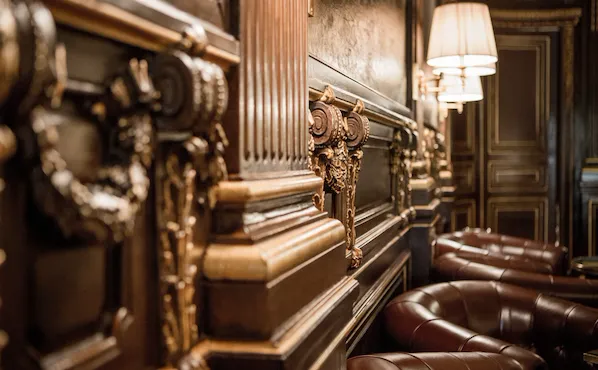 Wooden walls of the bar, with gold ornaments, at Le Meurice, Paris.