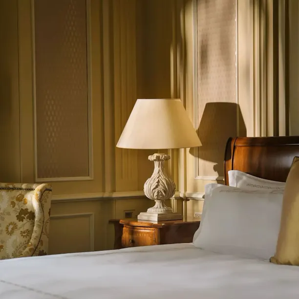 Classic room with soft cream and gold colors, wood details and bedside lamps