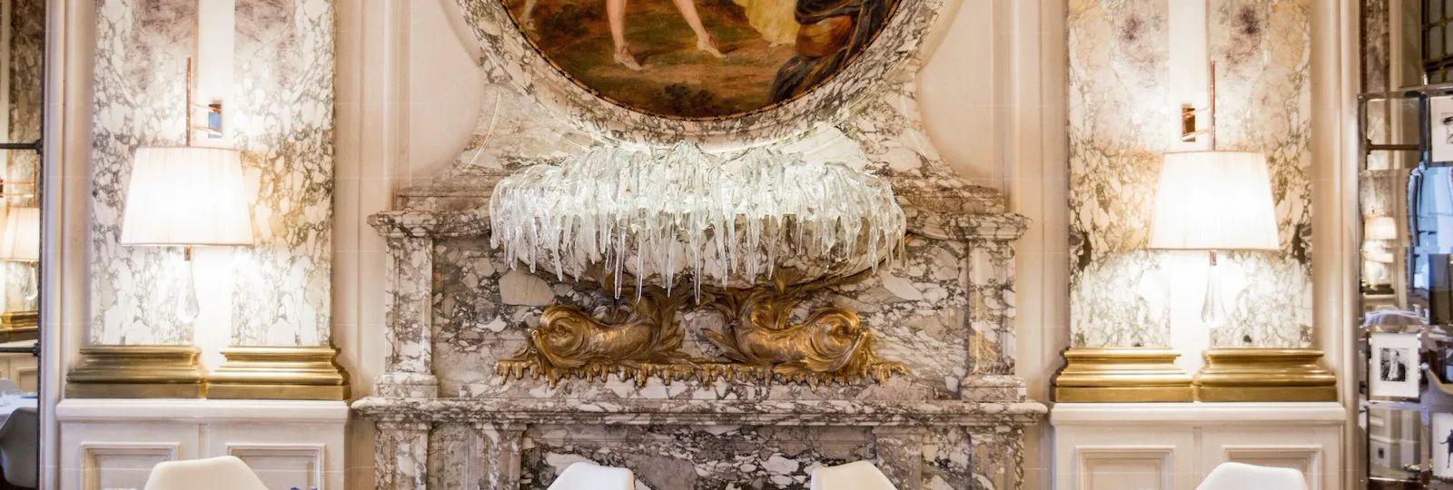 Landscape shot of two tables with a focus on the glass mural sculpture at Restaurant Le Meurice Alain Ducasse, at Le Meurice, Paris.