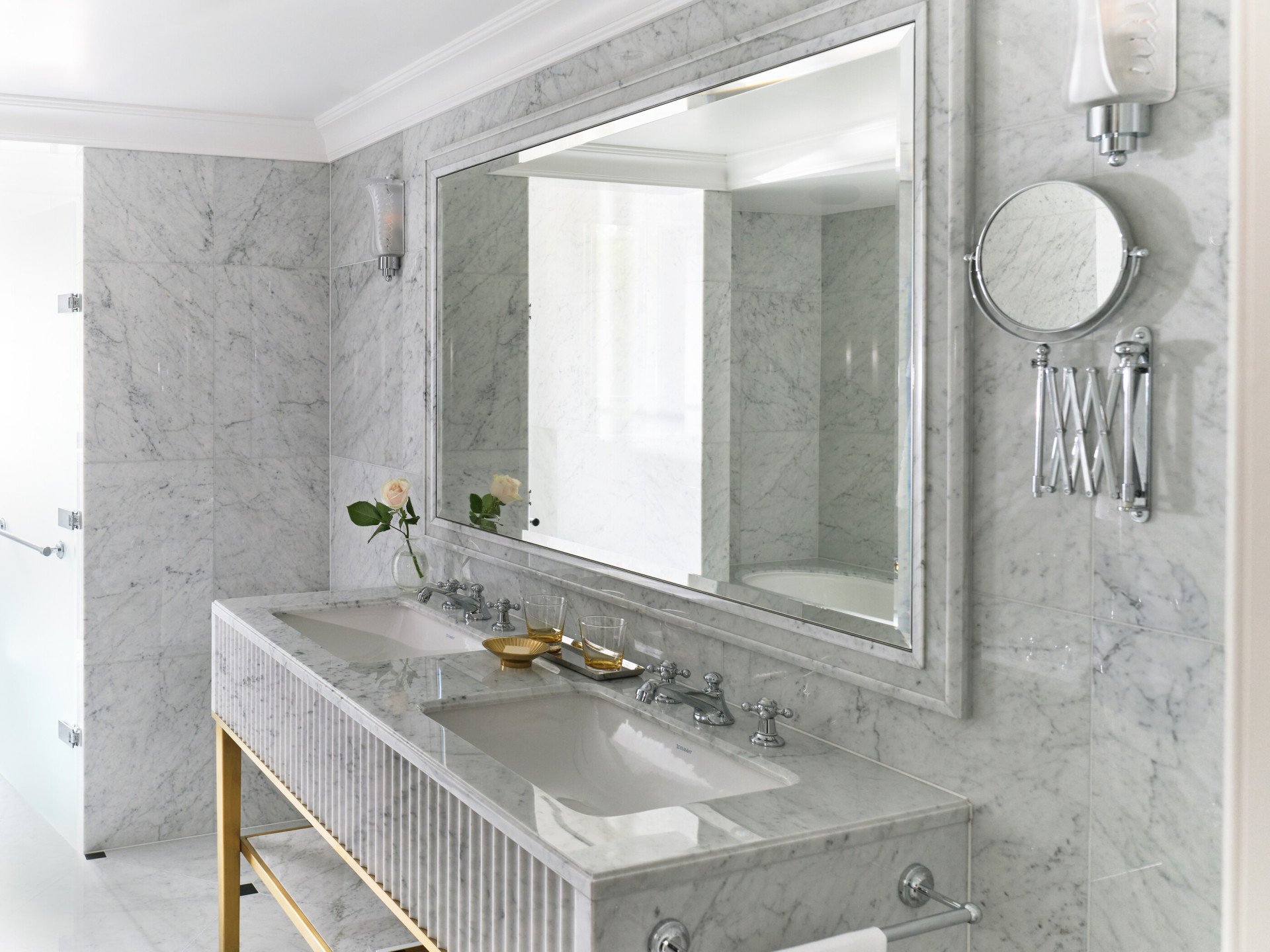 Deluxe Room at The Dorchester in Morning light bathroom mirror and sink with marble details