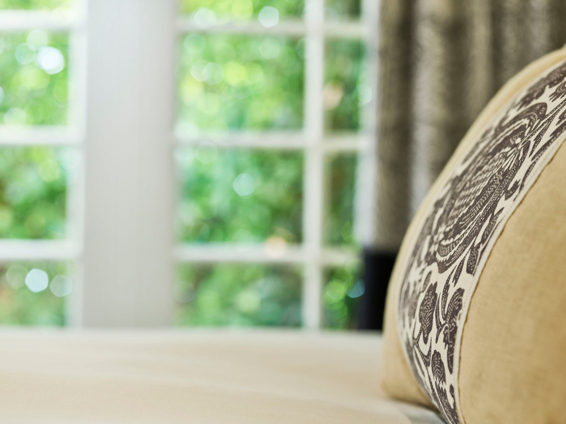 Detail of bed linen and view to gardens