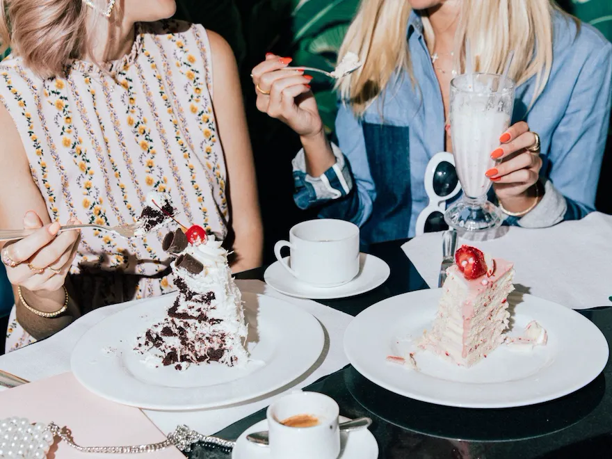 Friends eating cake and drinking milkshakes in The Fountain Coffee Room