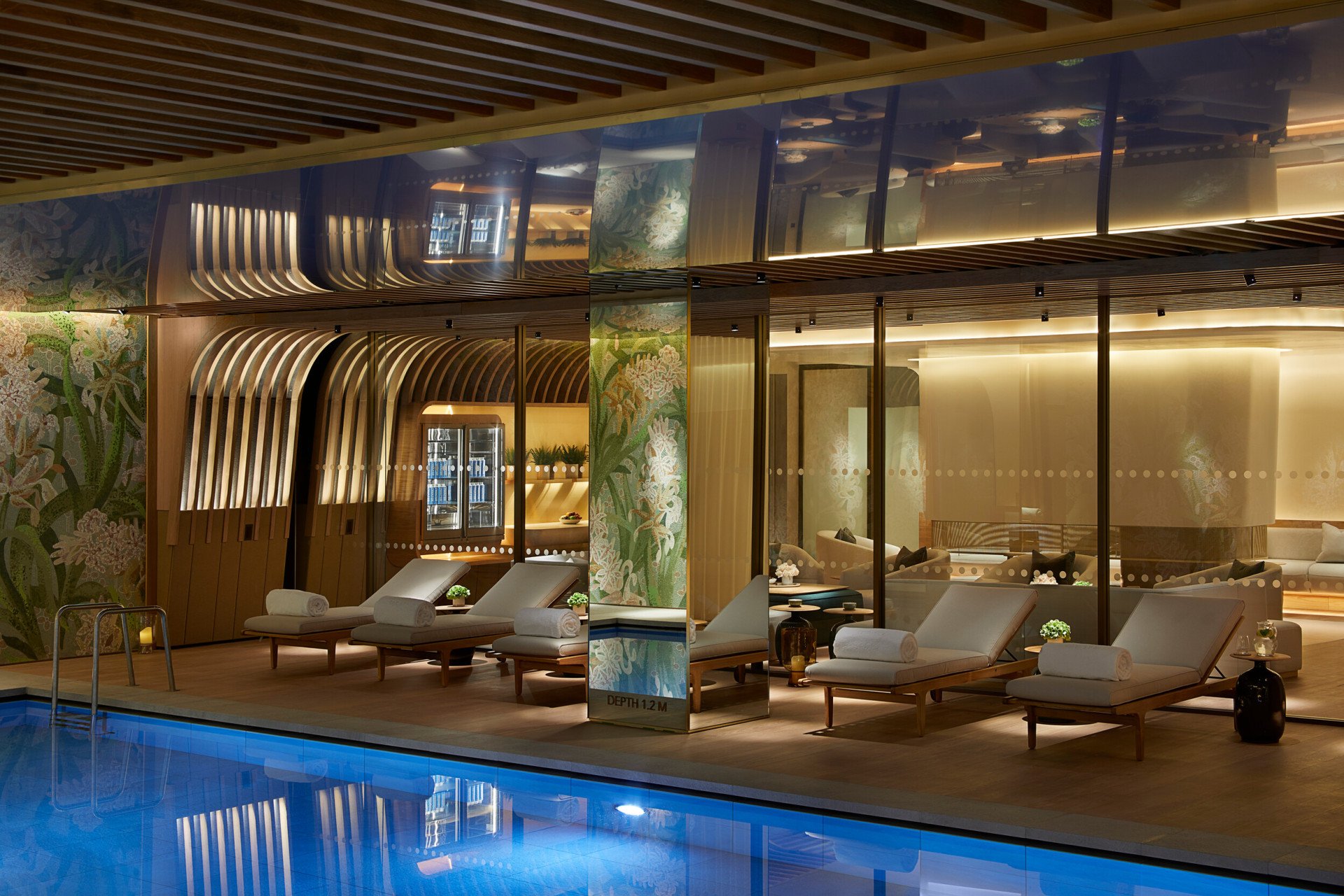 Five pool loungers lined up by swimming pool at The Spa at 45 Park Lane, London
