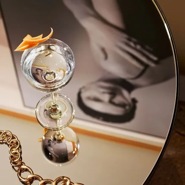 Close up on one of the tables in Il Salotto Lobby Lounge with a cocktail and the reflection of a hanging black and white picture