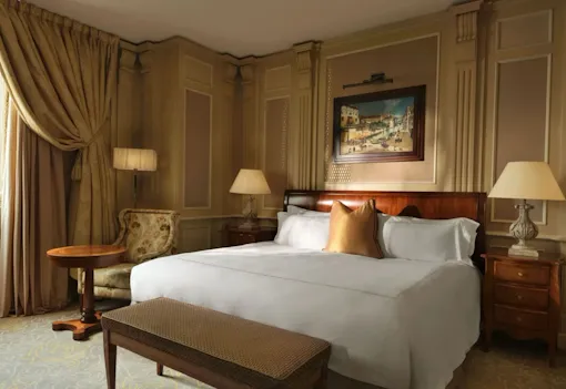 Classic room with soft cream and gold colors, wood details and bedside lamps