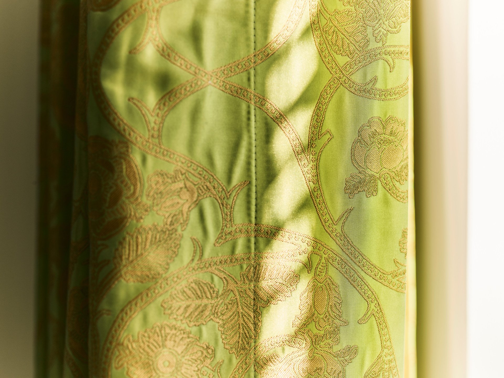 Detail of green curtain  with golden motif inside Junior Suite at Hotel Eden, Rome