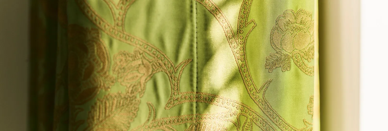Detail of green curtain with golden motif inside Junior Suite at Hotel Eden, Rome