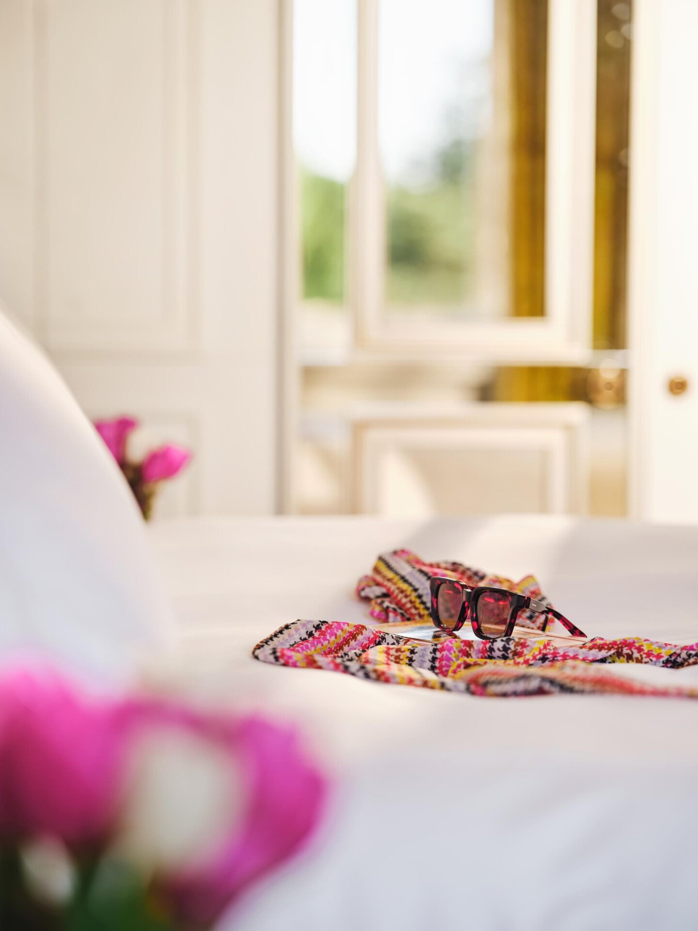 Scarf and sunglasses on bed in a room at Hotel Eden Rome