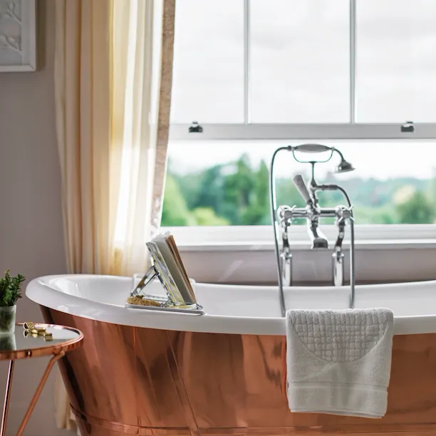 Copper bathtub with window nearby open with countryside view of Coworth Park, Ascot