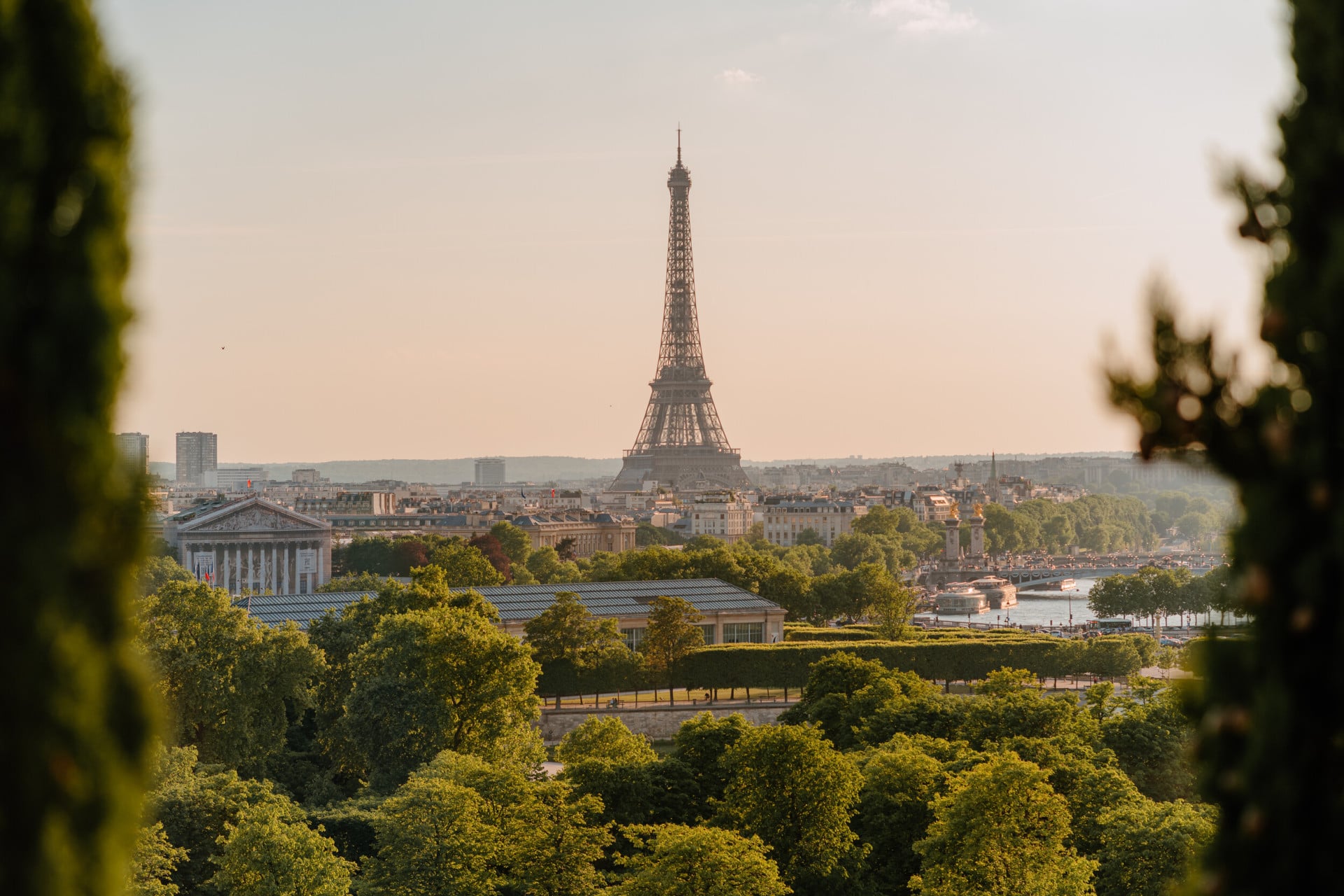 Distant andscape view of the Eiffel tower with trees surrounding the picture, at the Eiffel tower, Paris.