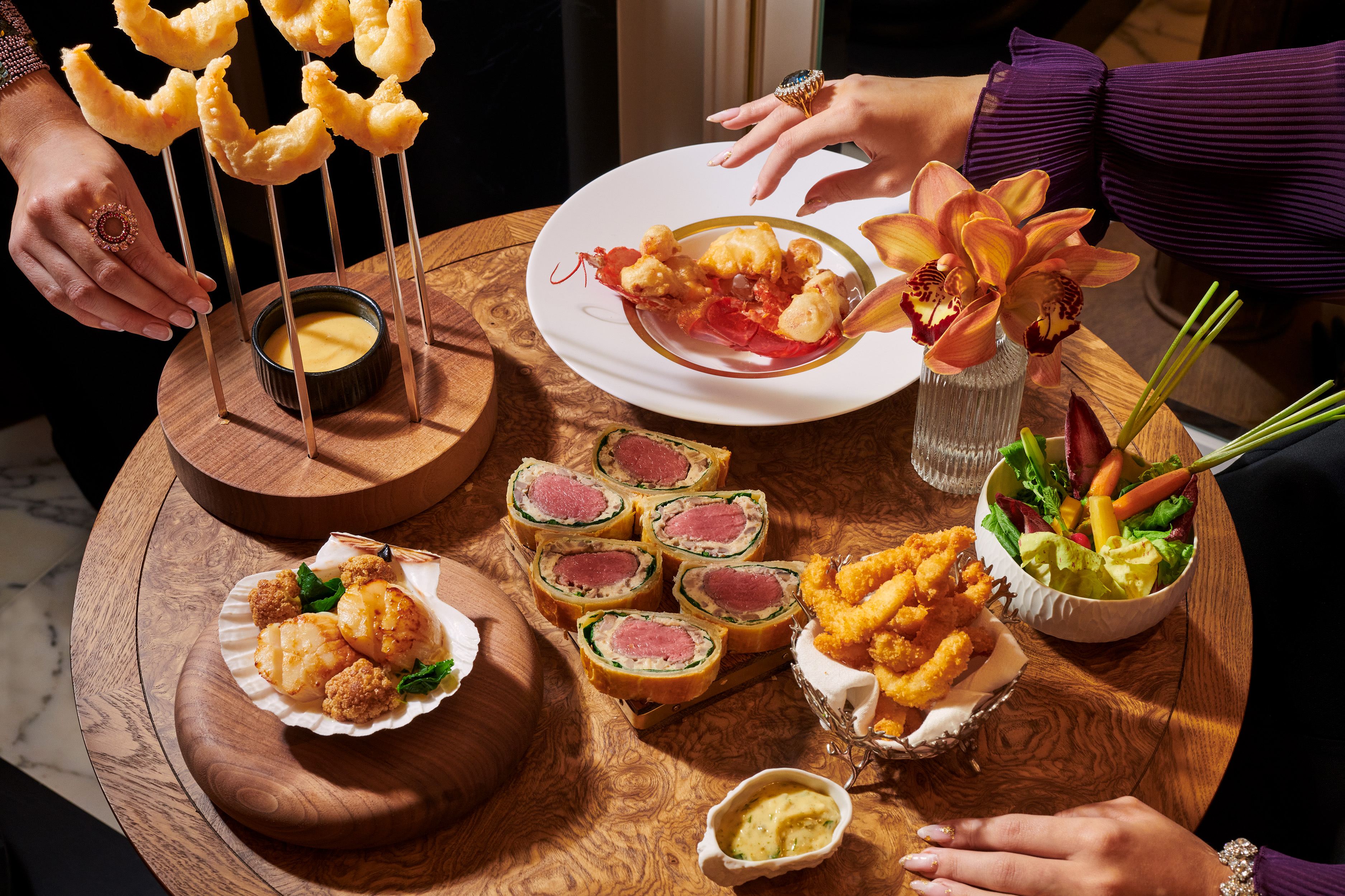 Beef wellington, lobster, scallops, prawns on brown table at Vesper Bar