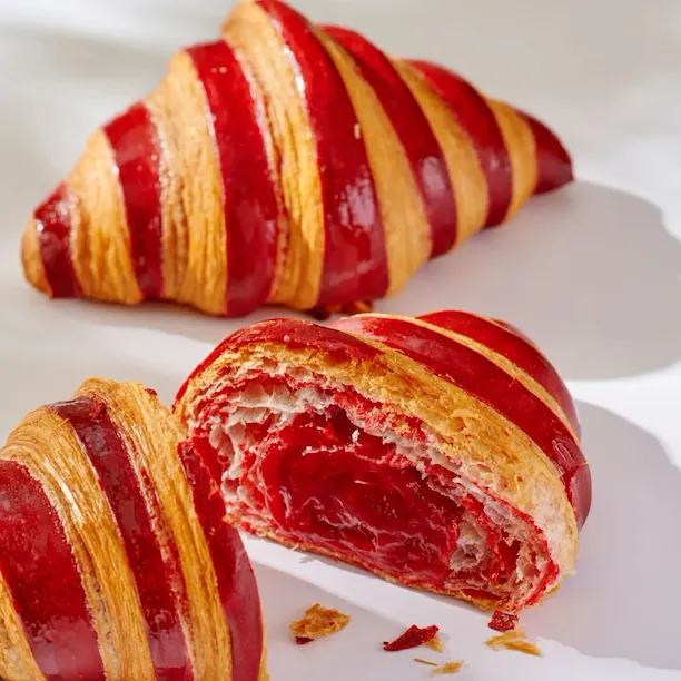 Pastry, viennoiseries and beverage offering at Bonbon Café Angelo Musa infront of a white backdrop with shadows.