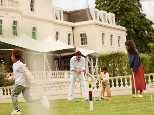family playing Croquet at Coworth Park in the evening light