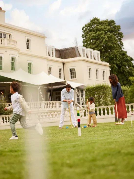 family playing Croquet at Coworth Park in the evening light