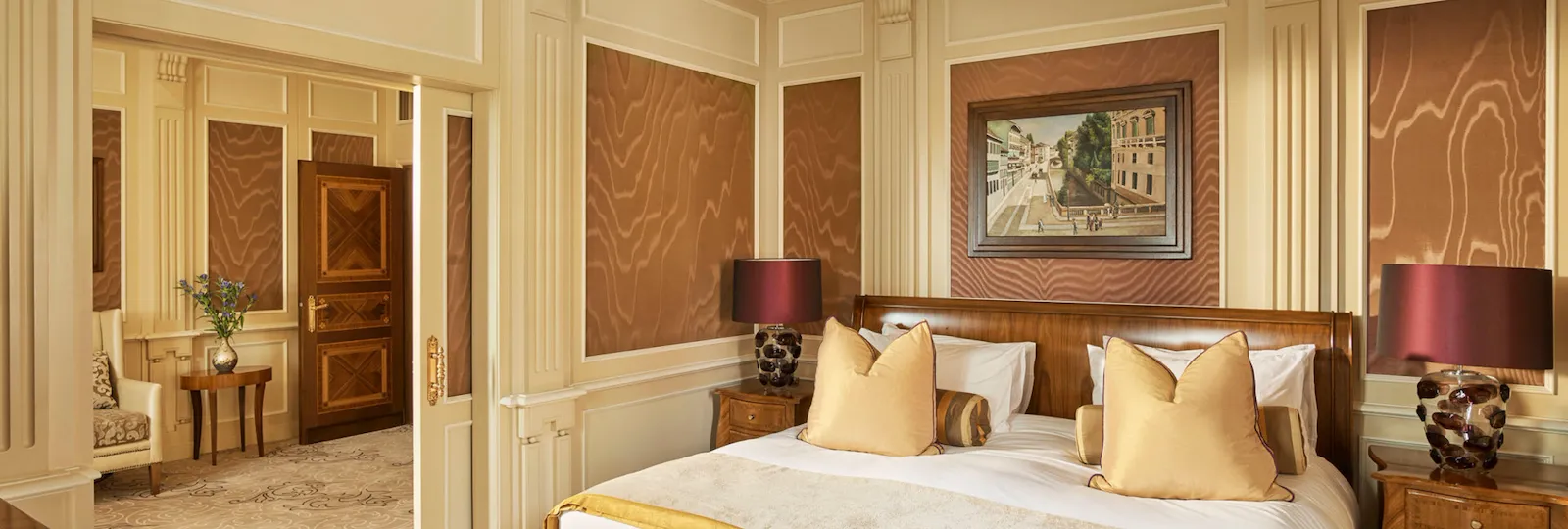 Ambassador Suite Bedroom decorated with warm colors but also touches of yellow and purple color