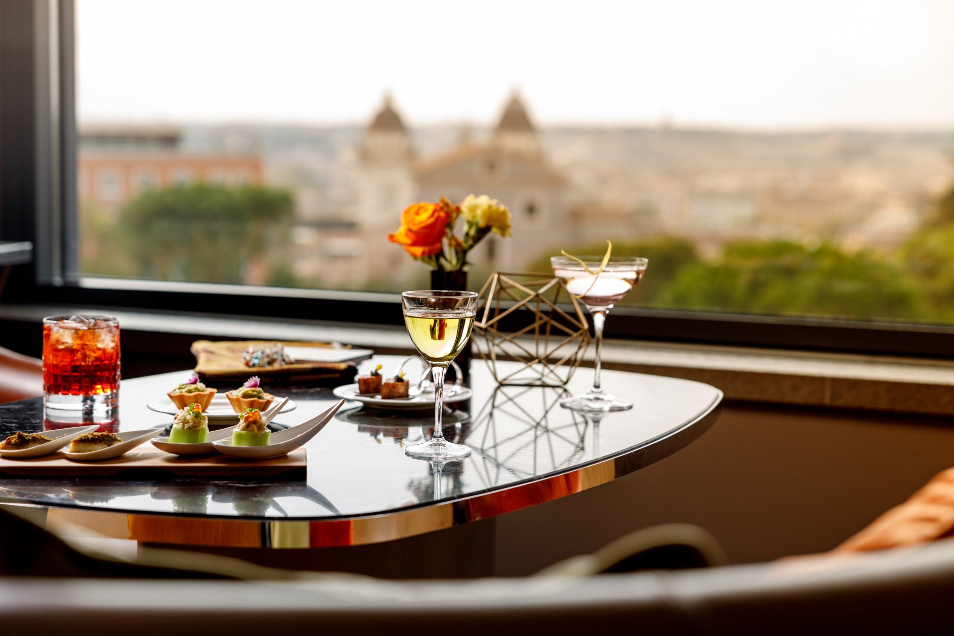 Aperitif with drinks and cicchetti served at Il Giardino Bar, panoramic Rome view on the background