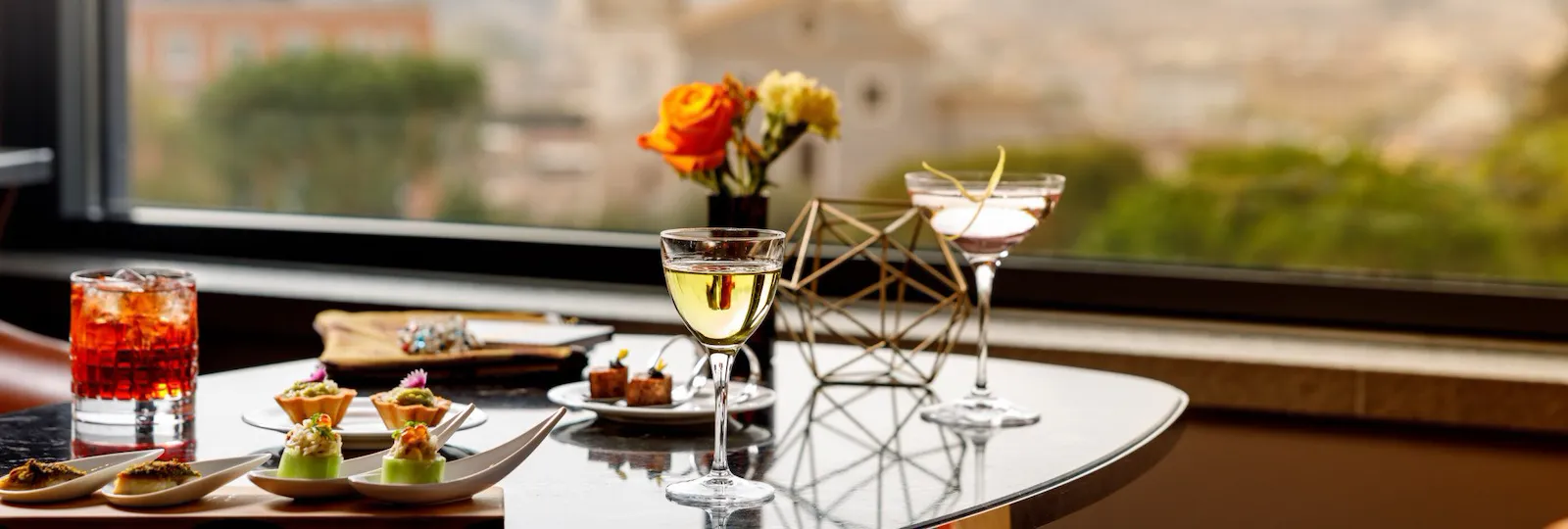 Aperitif with drinks and cicchetti served at Il Giardino Bar, panoramic Rome view on the background